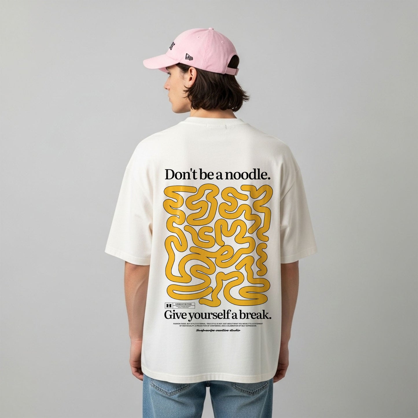 Person wearing a white t-shirt with yellow and black text and graphics on the back, standing against a plain background.