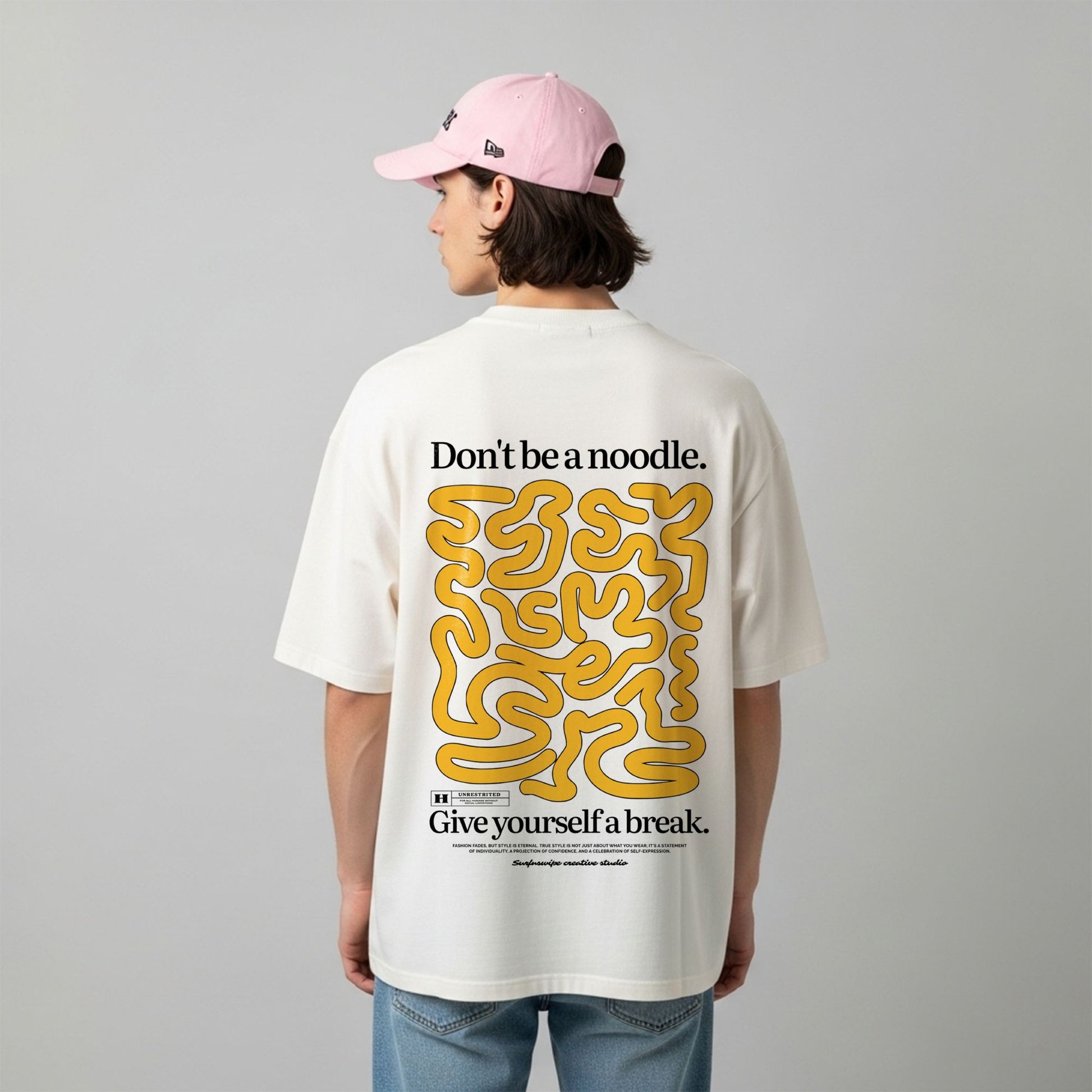 Person wearing a white t-shirt with yellow and black text and graphics on the back, standing against a plain background.