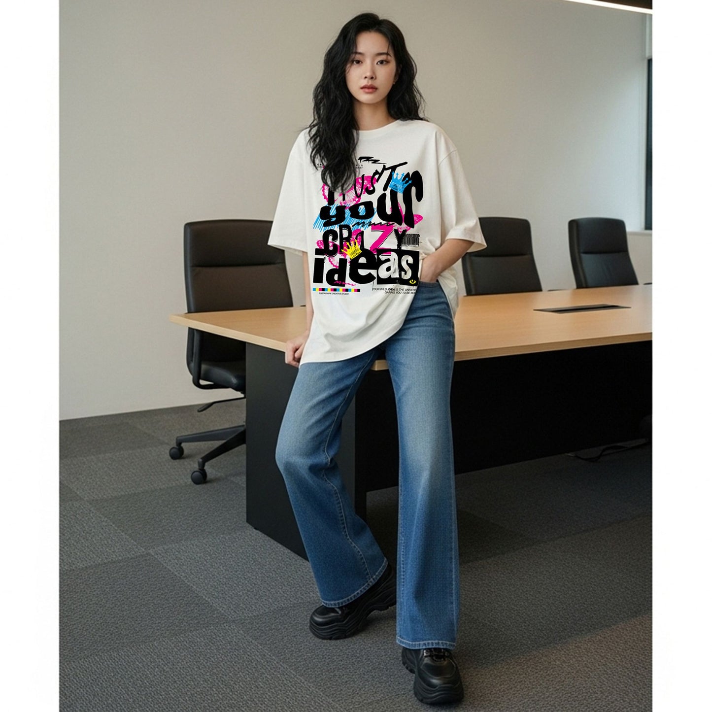 Person wearing a colorful t-shirt and blue jeans in an office setting