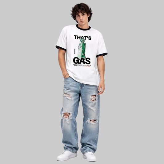 A model wearing a white ringer t-shirt with black trim and a green graphic print that reads 'THAT'S GAS', paired with distressed light blue jeans and white sneakers, against a light gray studio background.
