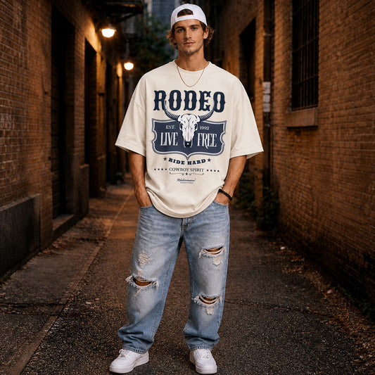 Man wearing a white t-shirt with 'Rodeo Live Free' design in a living room.