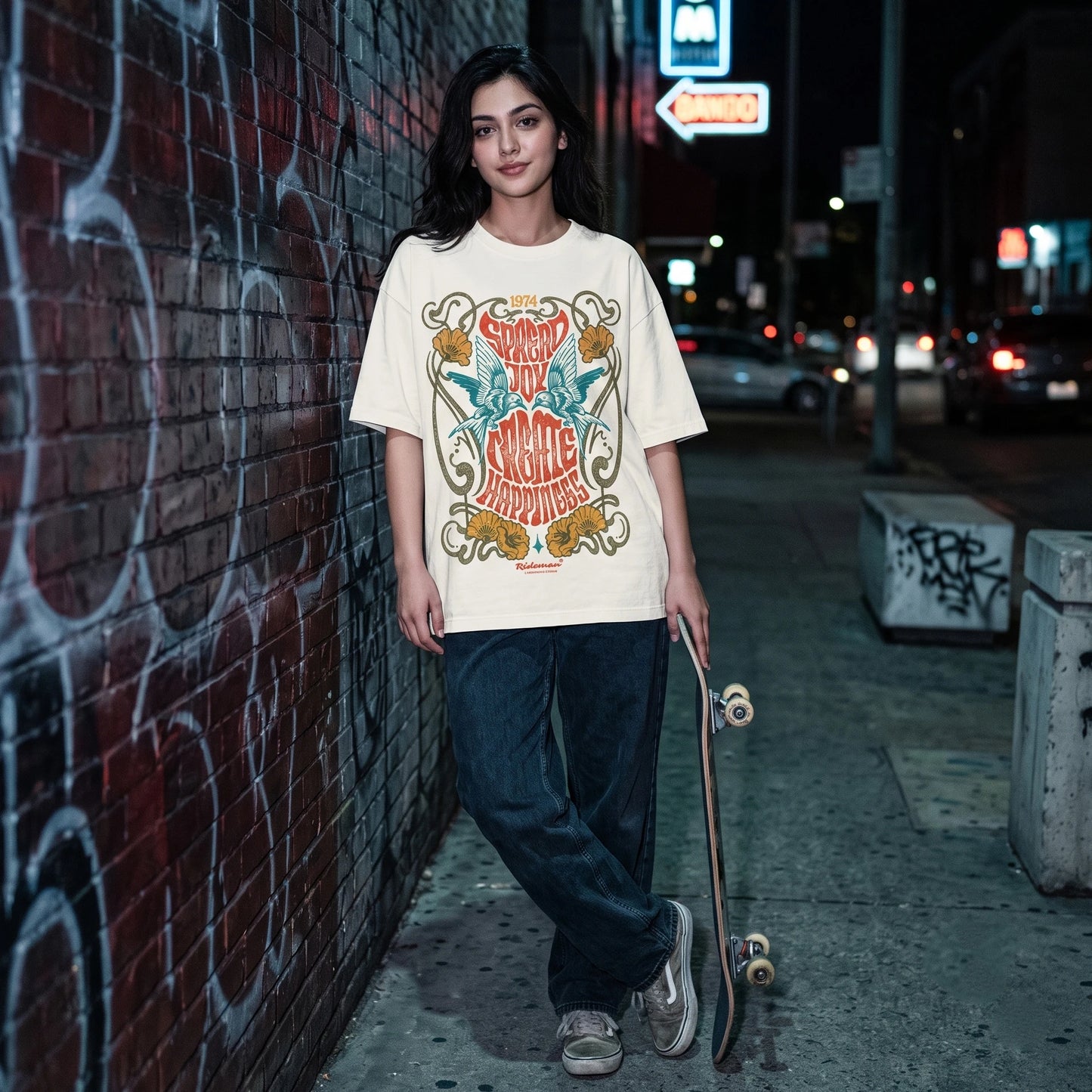 Person wearing a Vintage bird and floral print oversized tee holding a skateboard in an urban alleyway at night.