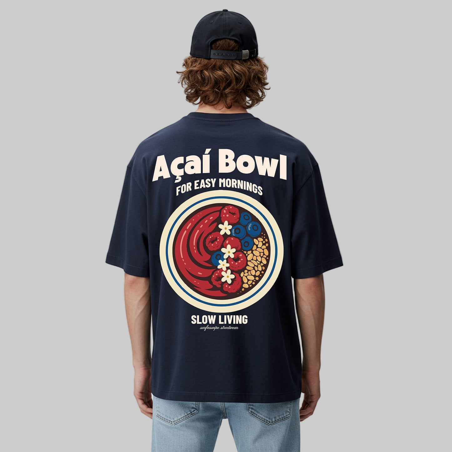 Person wearing a navy blue t-shirt with a colorful graphic and text on the back, standing against a light gray background.