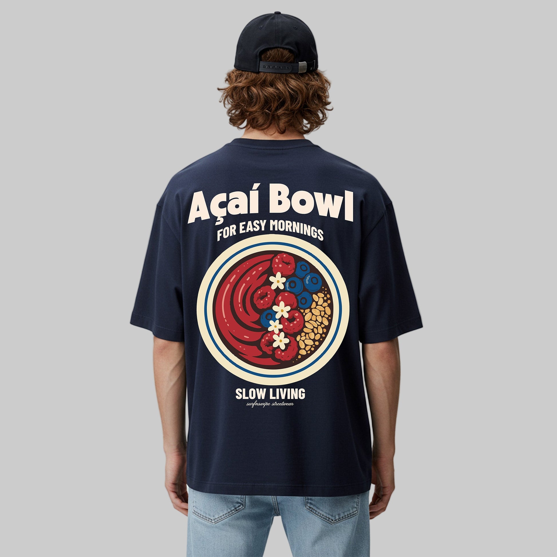 Person wearing a navy blue t-shirt with a colorful graphic and text on the back, standing against a light gray background.