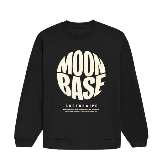 A black crewneck sweatshirt with a large cream-colored graphic on the front reading 'MOON BASE' in a circular design, with 'SURFNSWIPE' printed below it, shown against a plain white background.