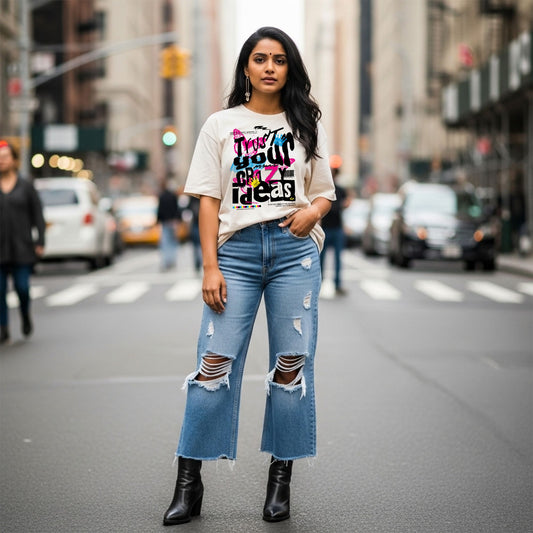 Woman wearing a graphic t-shirt and ripped jeans on a city street.