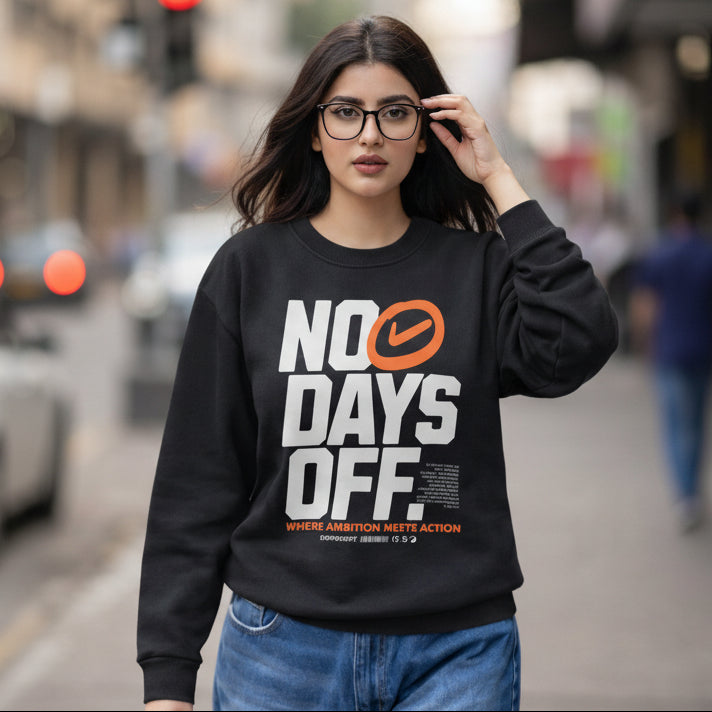 Woman wearing a black sweatshirt with 'NO DAYS OFF' text on a city street.