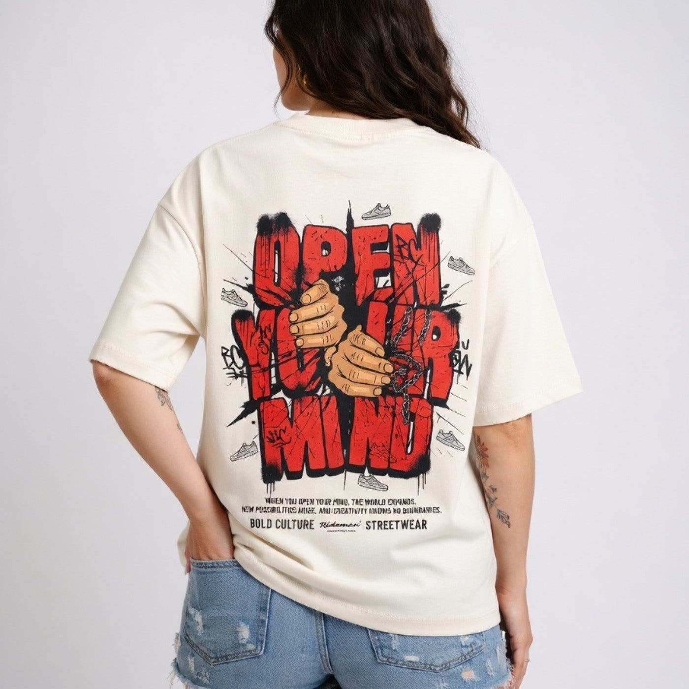 Person wearing a white t-shirt with a graphic design and text on the back, standing against a plain background.