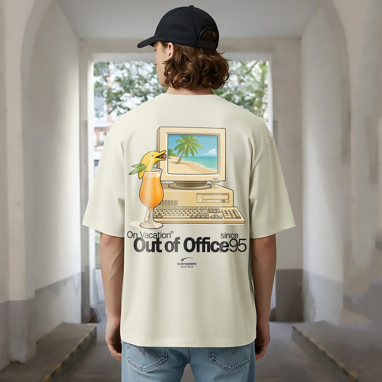 Person wearing a t-shirt with a graphic design of a computer and a drink, standing in an indoor setting.