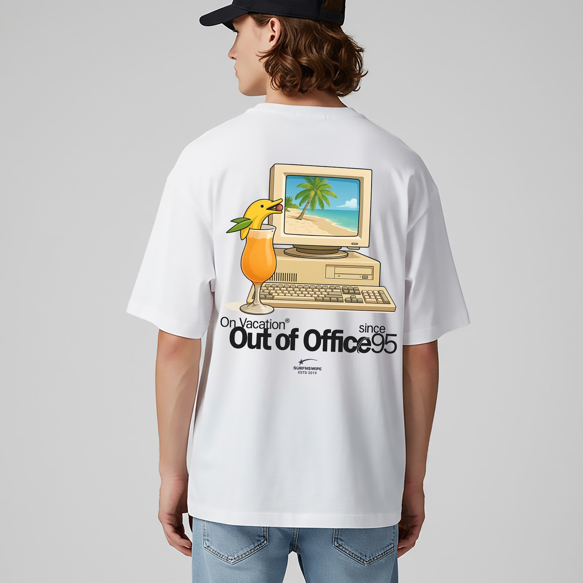 Person wearing a white t-shirt with a graphic design on the back, featuring a computer and palm tree, on a plain background.