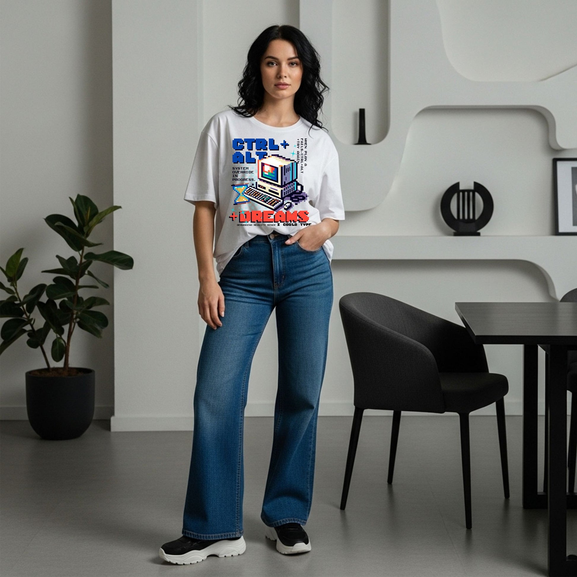 Woman wearing a graphic t-shirt and blue jeans standing in a modern room.