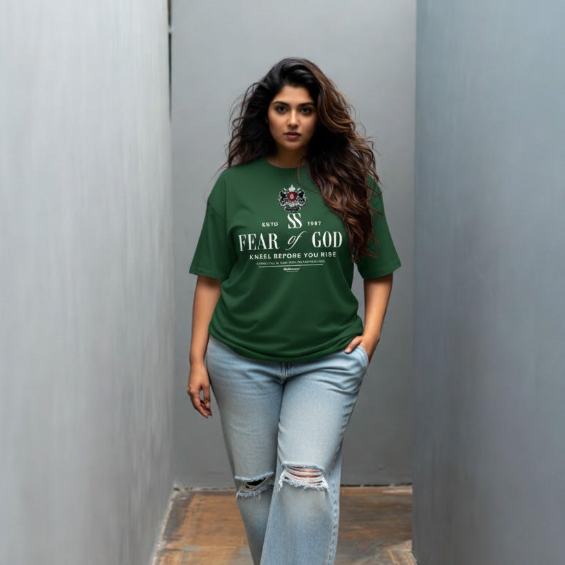 Woman wearing a green 'Fear of God' t-shirt against a plain background