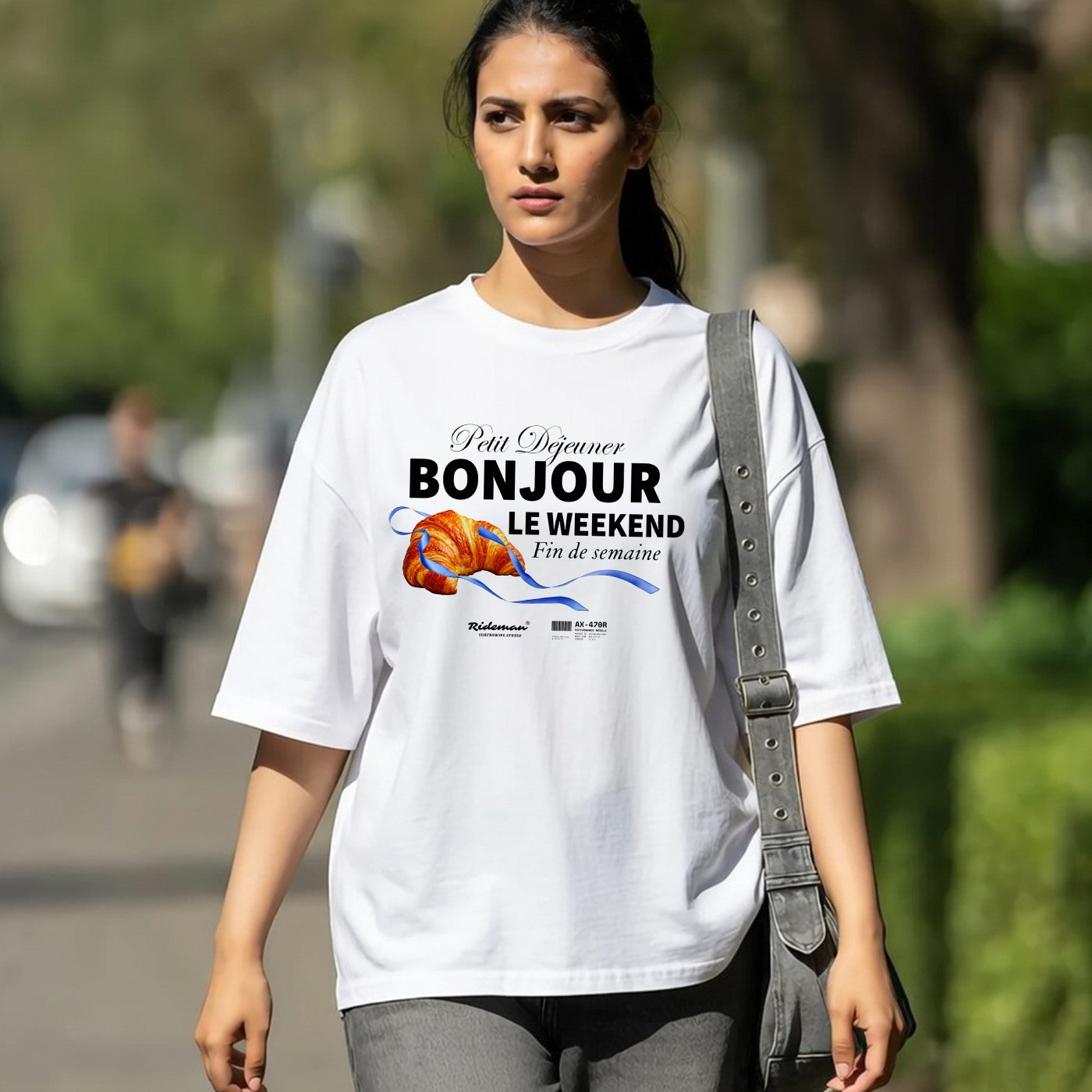Woman wearing a white t-shirt with a colorful graphic and text, walking outdoors.