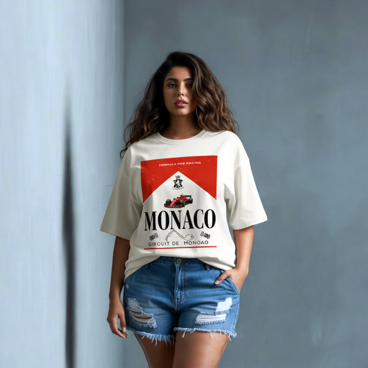Woman wearing a white t-shirt with Monaco graphic design against a gray wall