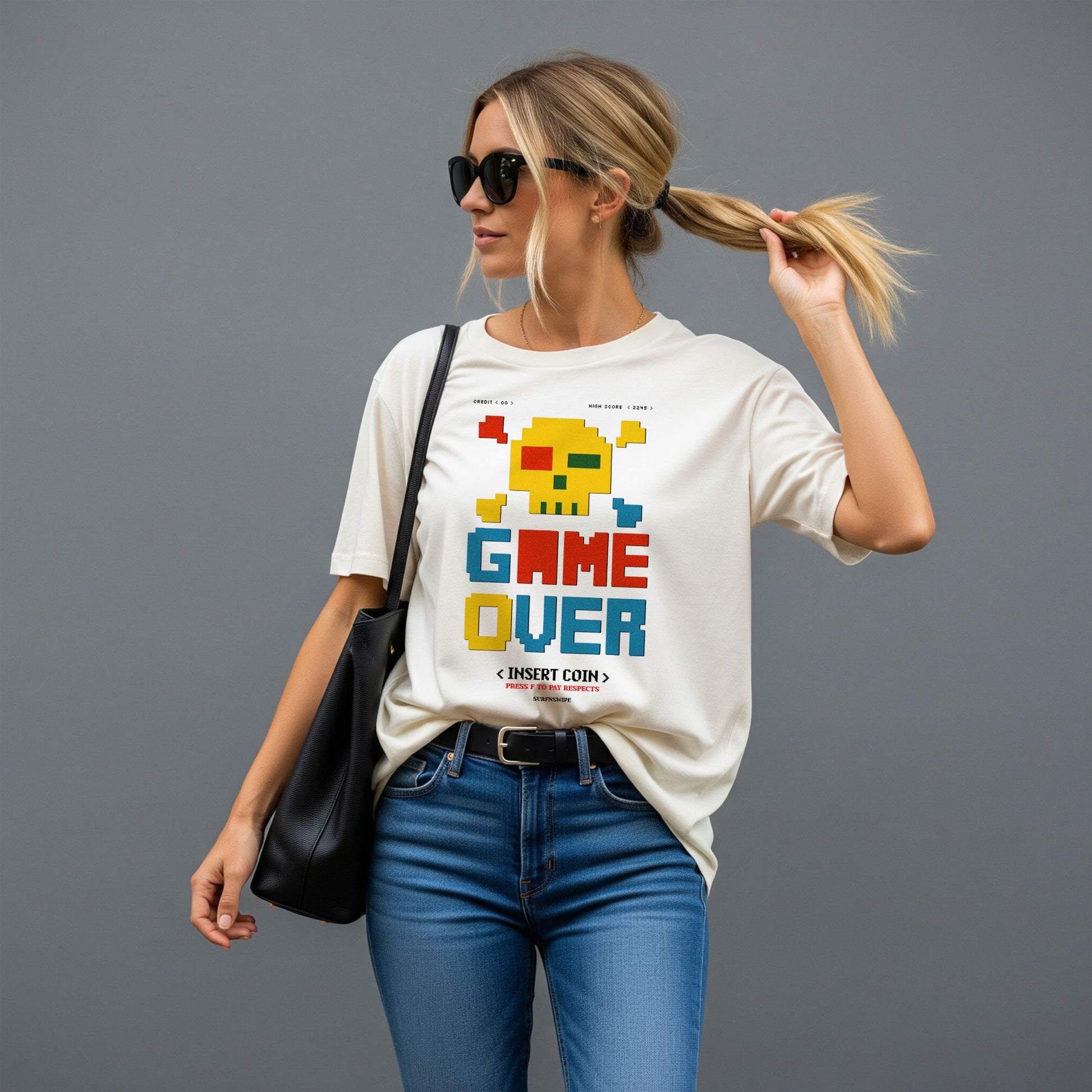 Woman wearing a white t-shirt with 'GAME OVER' graphic design on a gray background