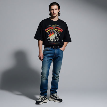 Person wearing a black t-shirt with a graphic design and blue jeans on a gray background