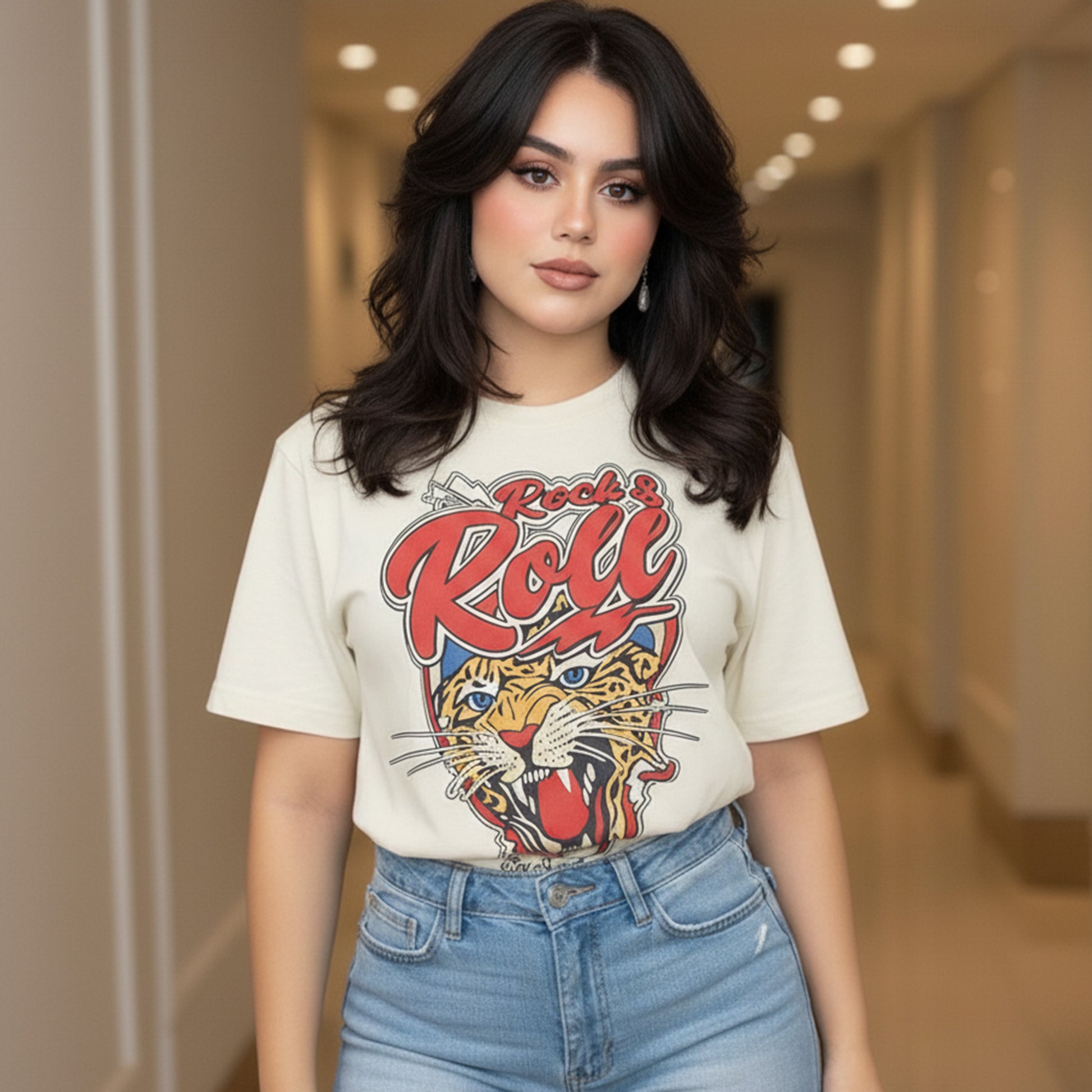 Woman wearing a t-shirt with a 'Rock & Roll' design and blue jeans in an indoor setting.
