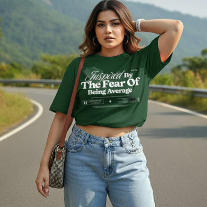 Woman wearing a green t-shirt with text on a road with mountains in the background
