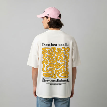 Person wearing a white t-shirt with yellow and black text and graphics on the back, standing against a plain background.