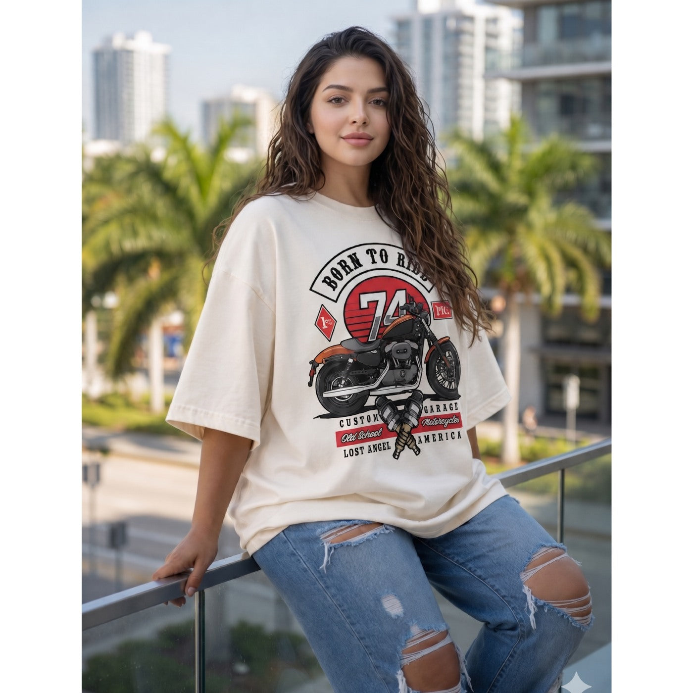 Woman wearing a graphic t-shirt with a motorcycle design in an urban setting.