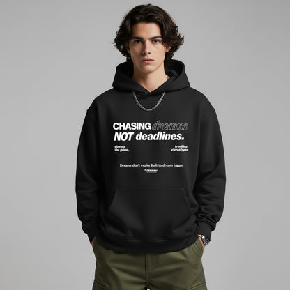 Person wearing a black hoodie with text on a gray background