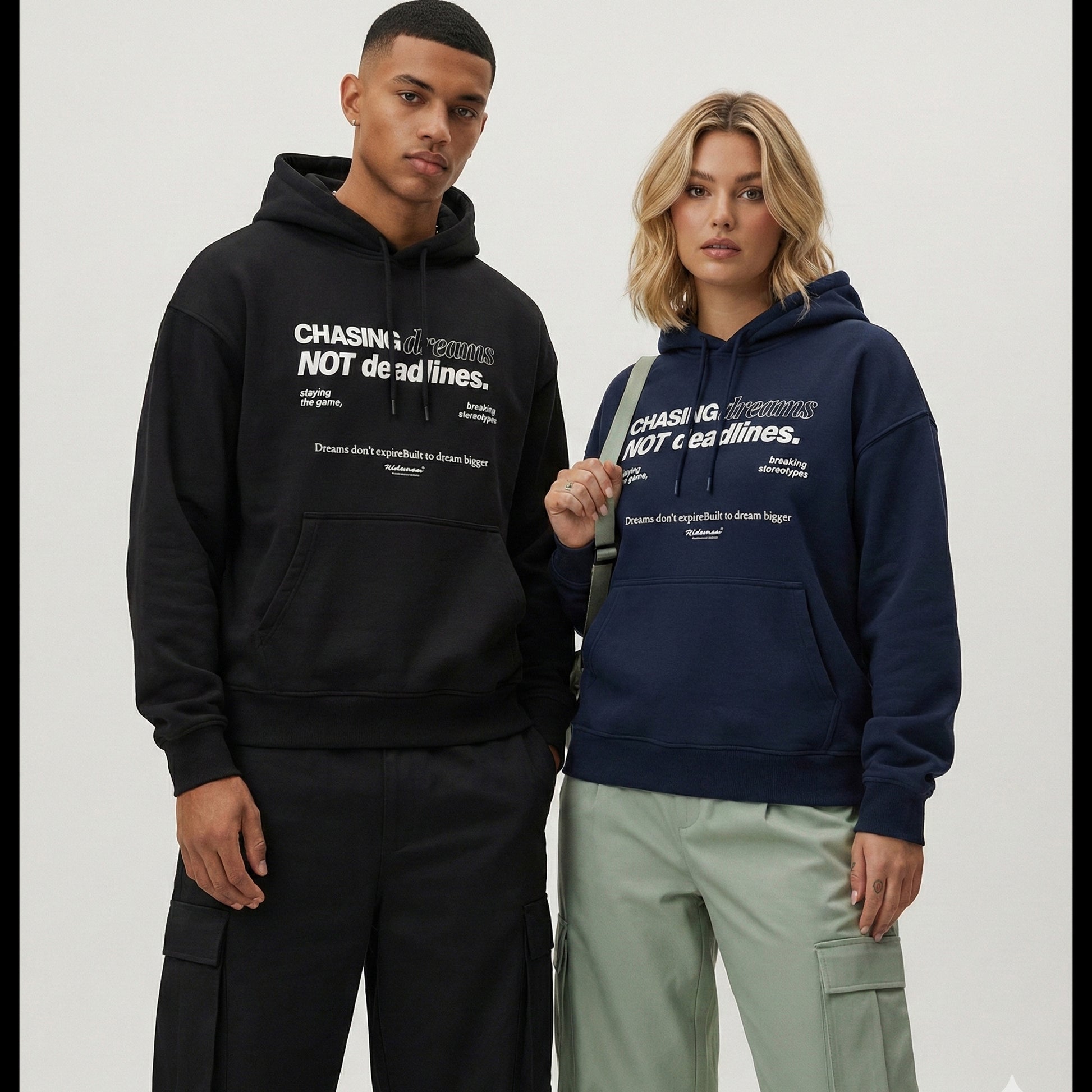 Two people wearing hoodies with a motivational quote on a plain background