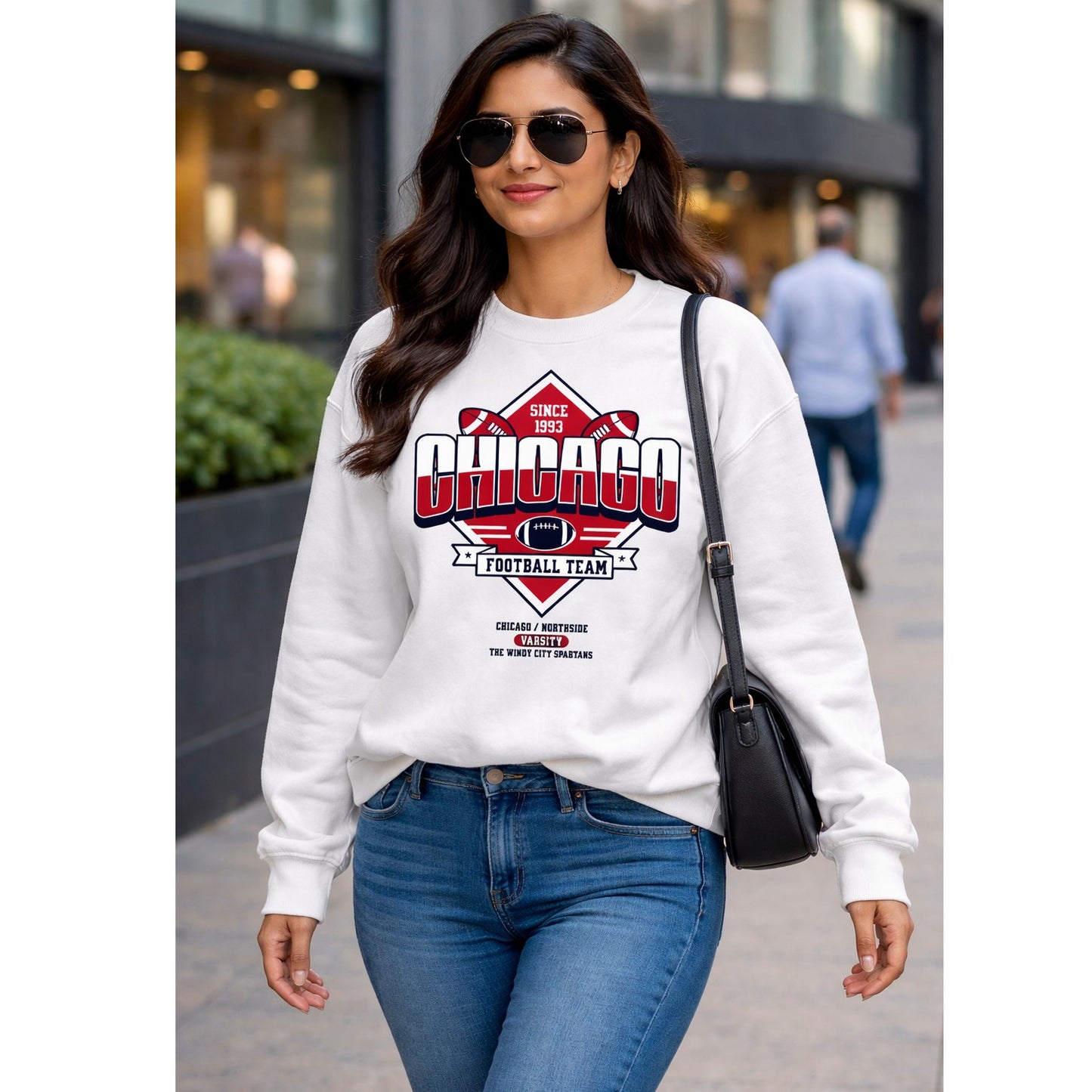 Woman wearing a white sweatshirt with 'Chicago Football Team' design, walking on a street.