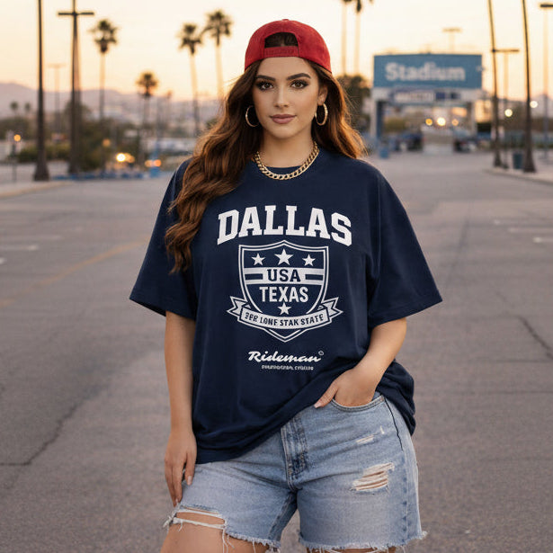 Woman wearing a navy blue t-shirt with 'Dallas, USA, Texas' text and graphics, standing in an outdoor setting.