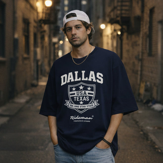 Person wearing a navy blue 'Dallas, USA Texas' t-shirt in an urban setting