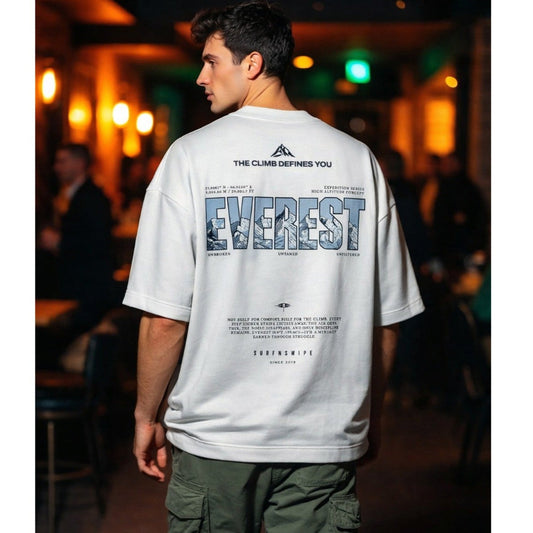 Person wearing a white t-shirt with 'Everest' design in an indoor setting