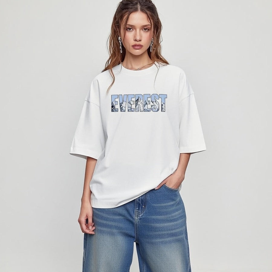 Woman wearing a white t-shirt with 'Everest' printed on it against a plain background