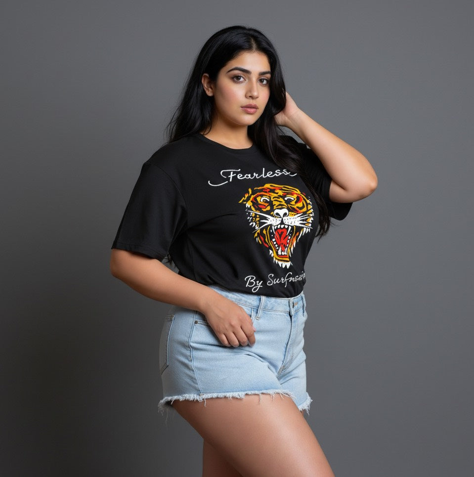 Woman wearing a black t-shirt with a tiger graphic and text, standing against a gray background