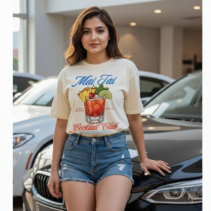Woman wearing a 'Mai Tai Cocktail Club' t-shirt standing in front of cars