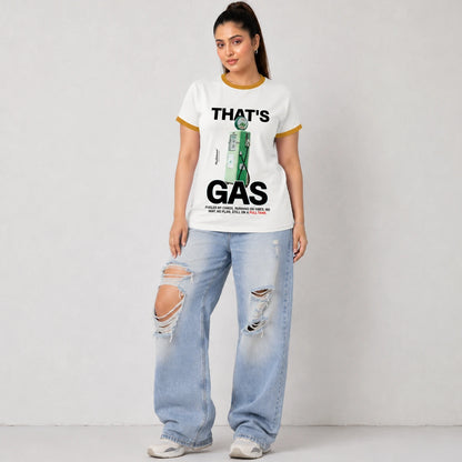 A woman modeling a white ringer t-shirt with yellow trim and a green gas station graphic that reads 'THAT'S GAS'. She is wearing light-wash, distressed wide-leg jeans and white sneakers, standing against a light gray wall.