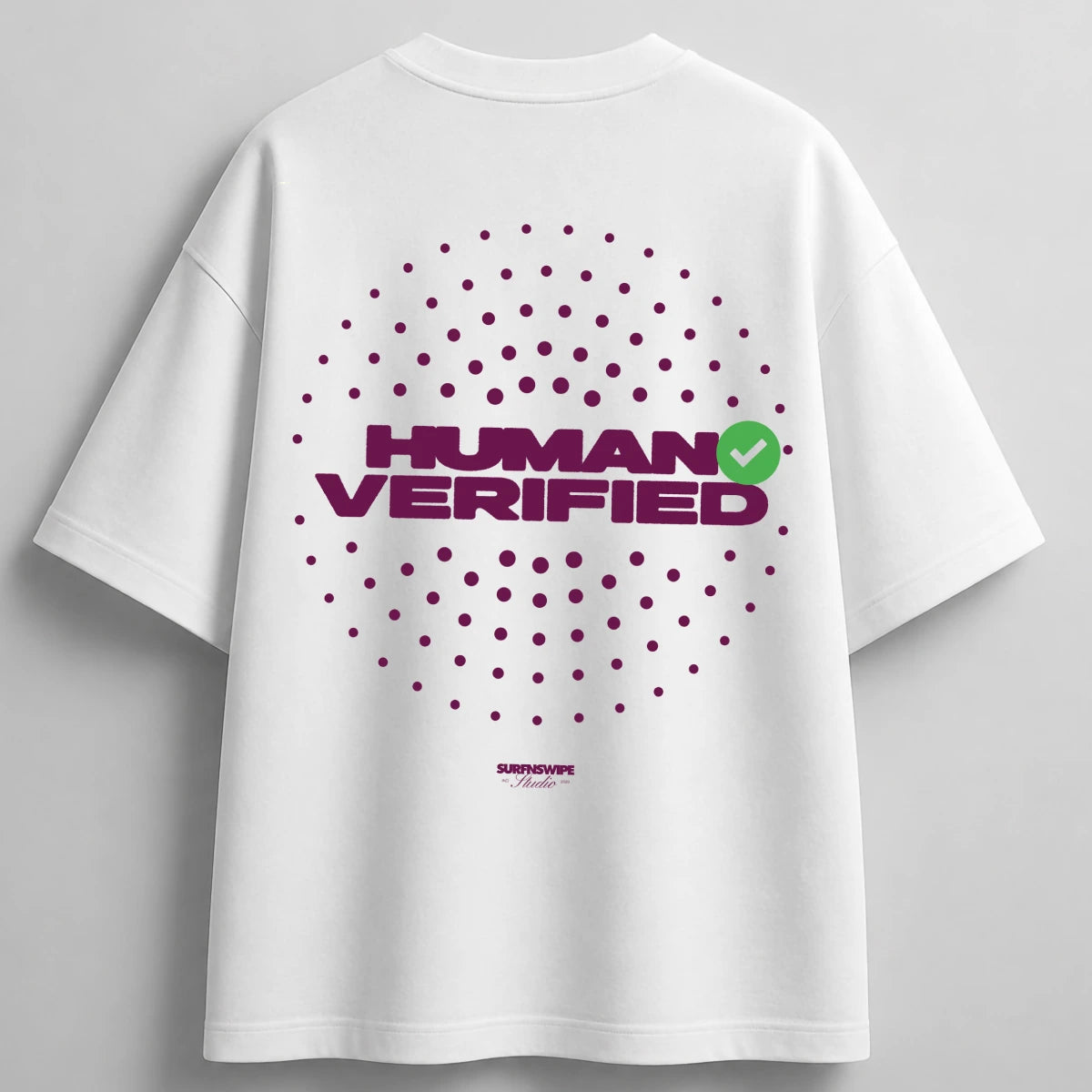 White oversized short-sleeve t-shirt with a purple circular dot graphic and 'HUMAN VERIFIED' text on the back, featuring a small green checkmark accent and 'SUBSHOWE' branding below.