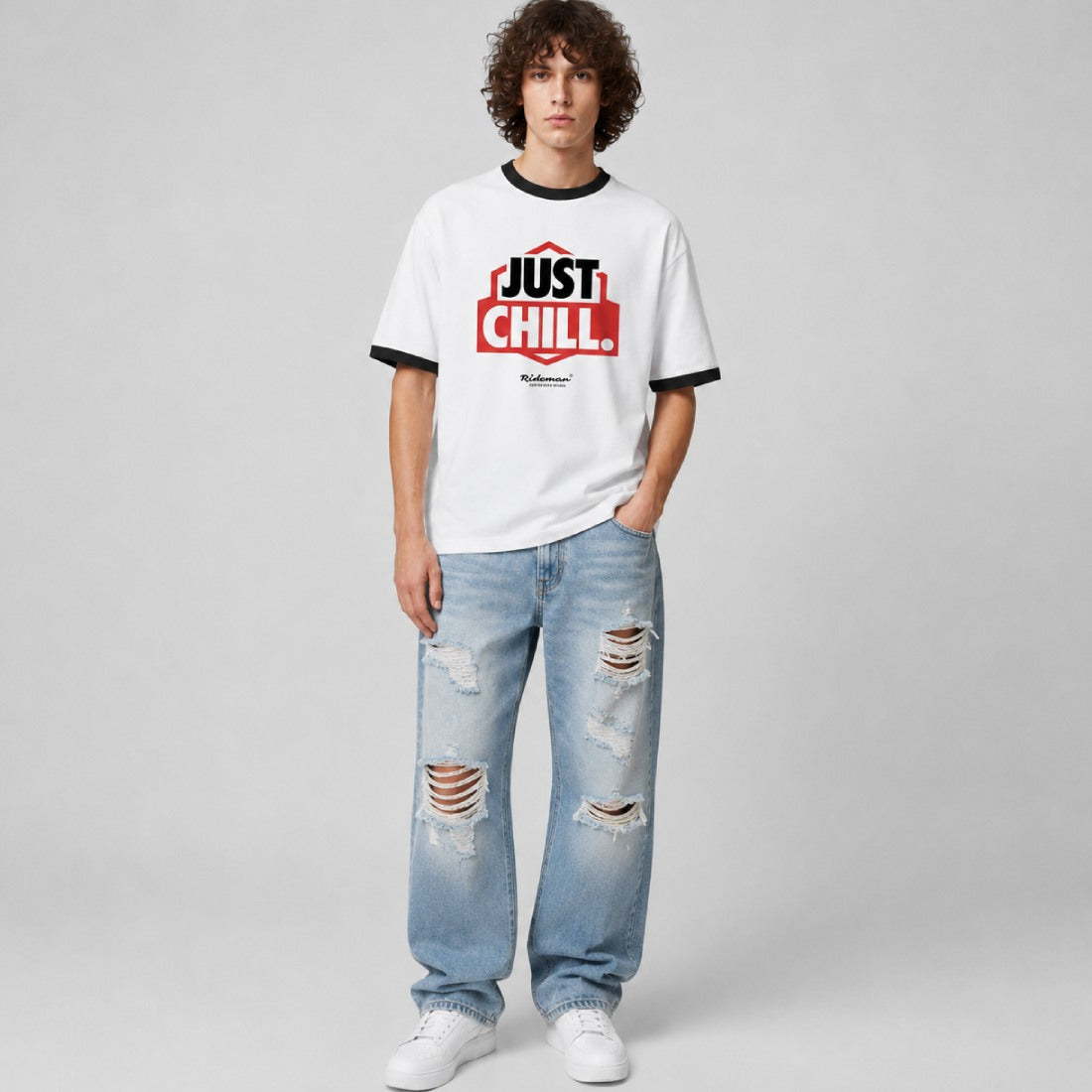 Person wearing a white t-shirt with 'Just Chill' text and ripped jeans on a gray background