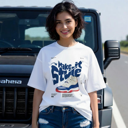 Woman wearing a white t-shirt with graphic design in front of a black SUV.