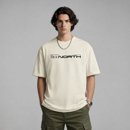 Person wearing a beige t-shirt with 'True North' text on a gray background