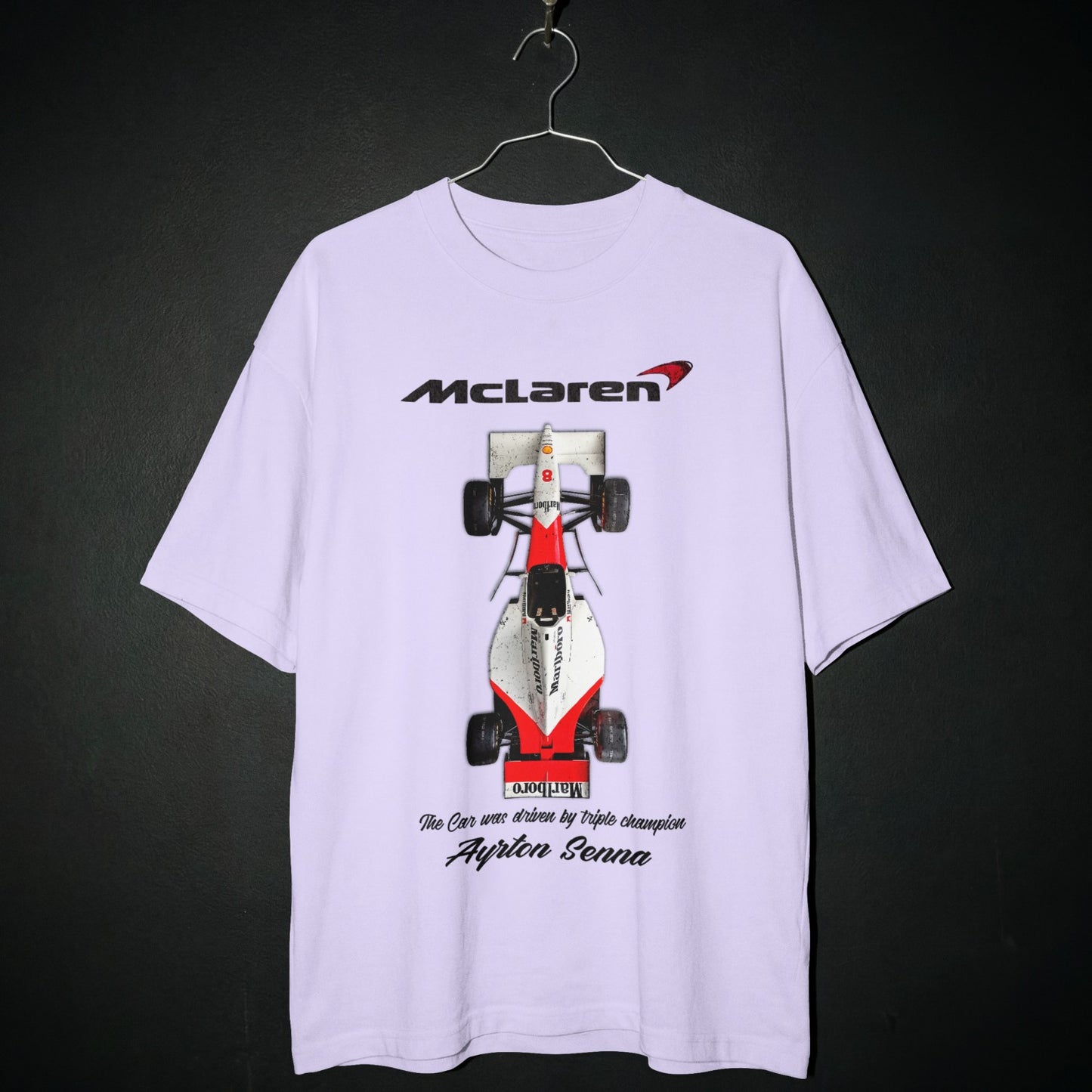 White t-shirt with McLaren Formula 1 car graphic on a dark background