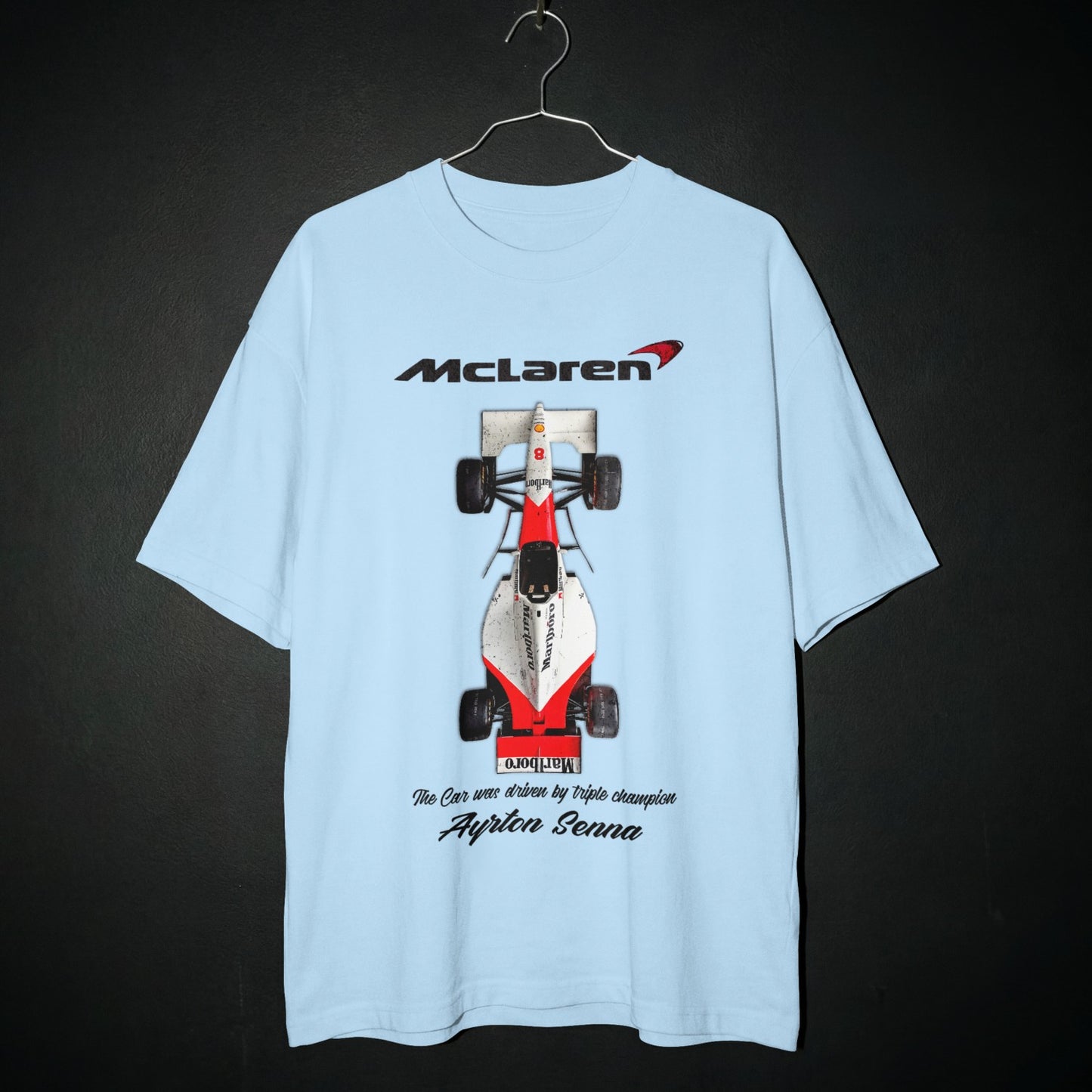 Light blue t-shirt with McLaren Formula 1 car graphic on a dark background
