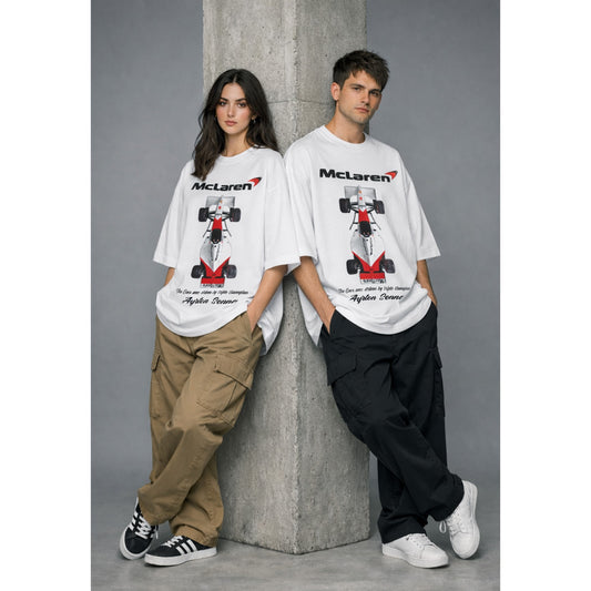 Two people wearing McLaren t-shirts with a race car graphic against a gray background