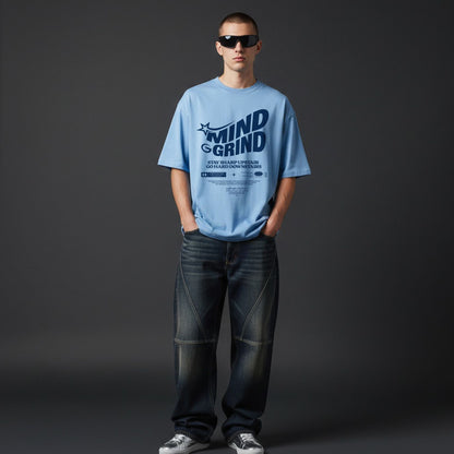 Person wearing a blue t-shirt with 'MIND GRIND' text on a dark background