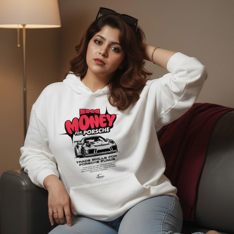 Woman wearing a white hoodie with a graphic design sitting on a couch.