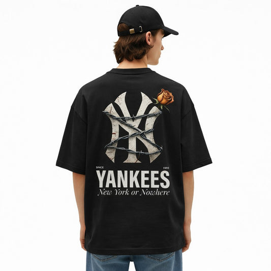 Person wearing a black t-shirt with Yankees logo and rose design on the back, standing against a white background.