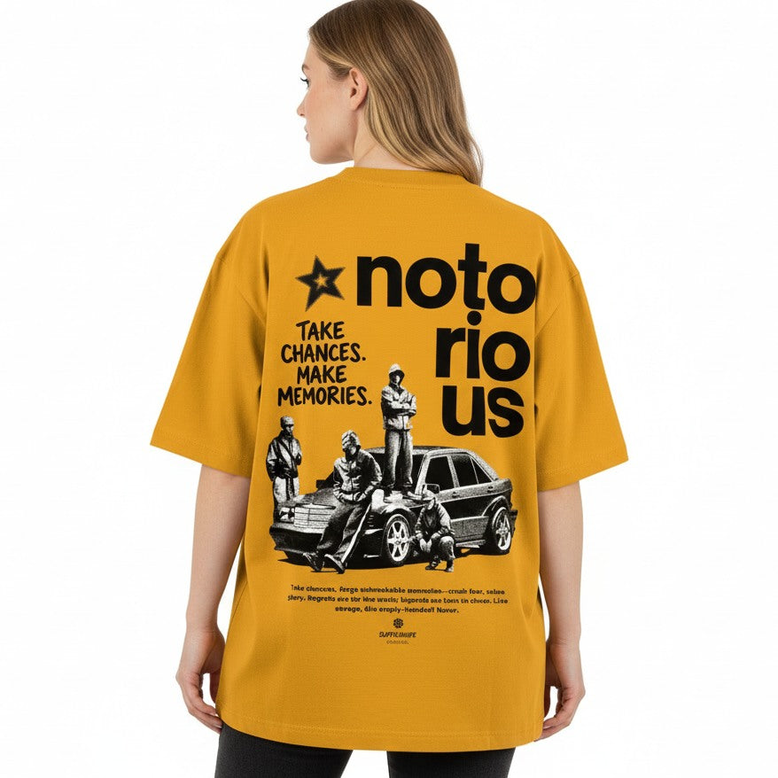 Person wearing a mustard yellow t-shirt with black graphics and text on the back.