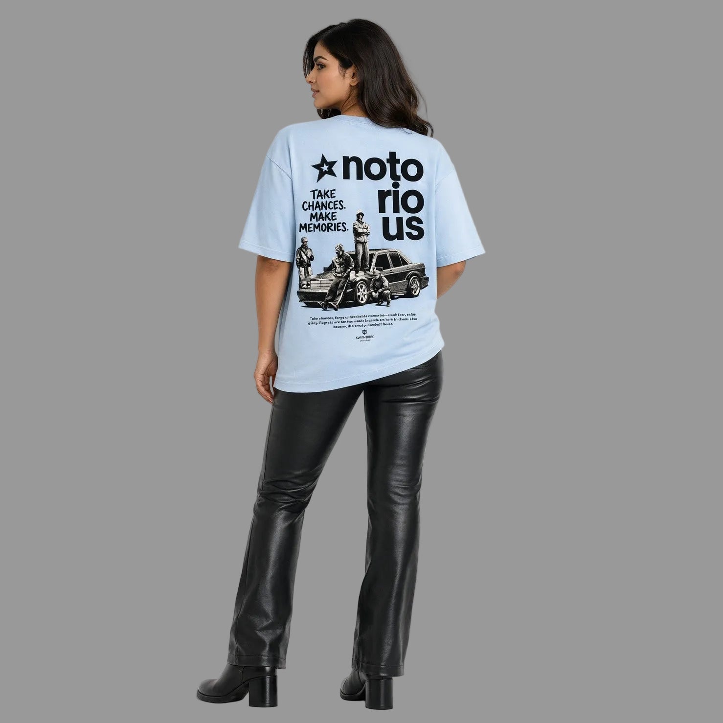 Person wearing a light blue t-shirt with a graphic design and text, standing against a white background