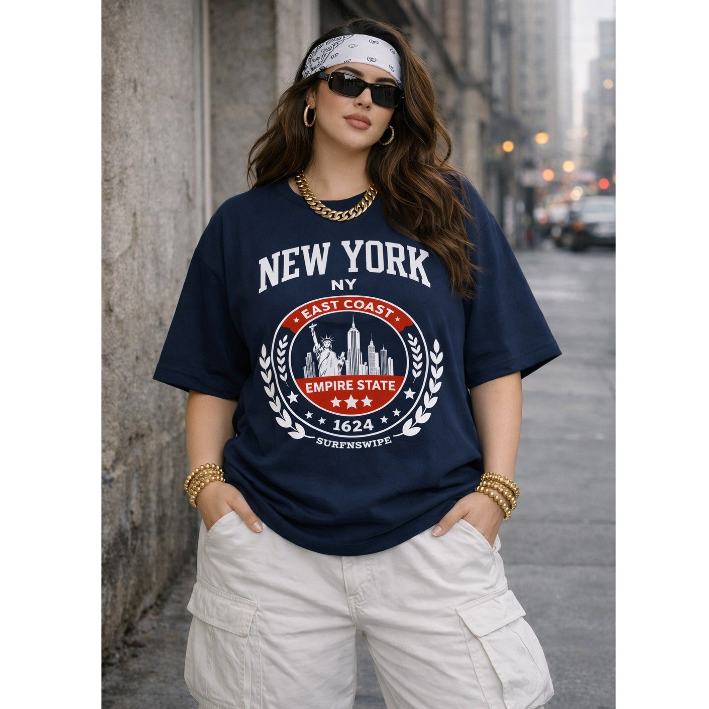 Woman wearing a navy blue t-shirt with 'New York' and 'Empire State' design on a city street.