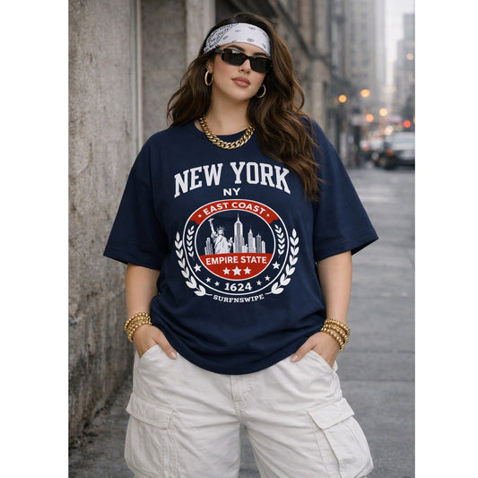 Woman wearing a navy blue t-shirt with 'New York' and 'Empire State' design on a city street.