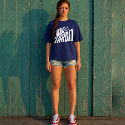 Person wearing a royal blue t-shirt with 'On Target' text standing against a green wooden wall.