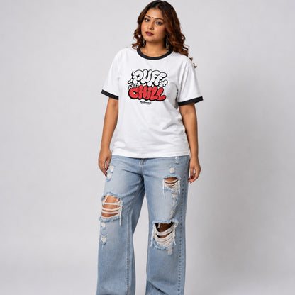 Woman wearing a white t-shirt with text and ripped jeans on a plain background